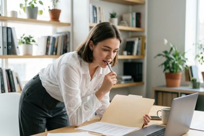 Jeune femme concentrée examinant un contrat au bureau